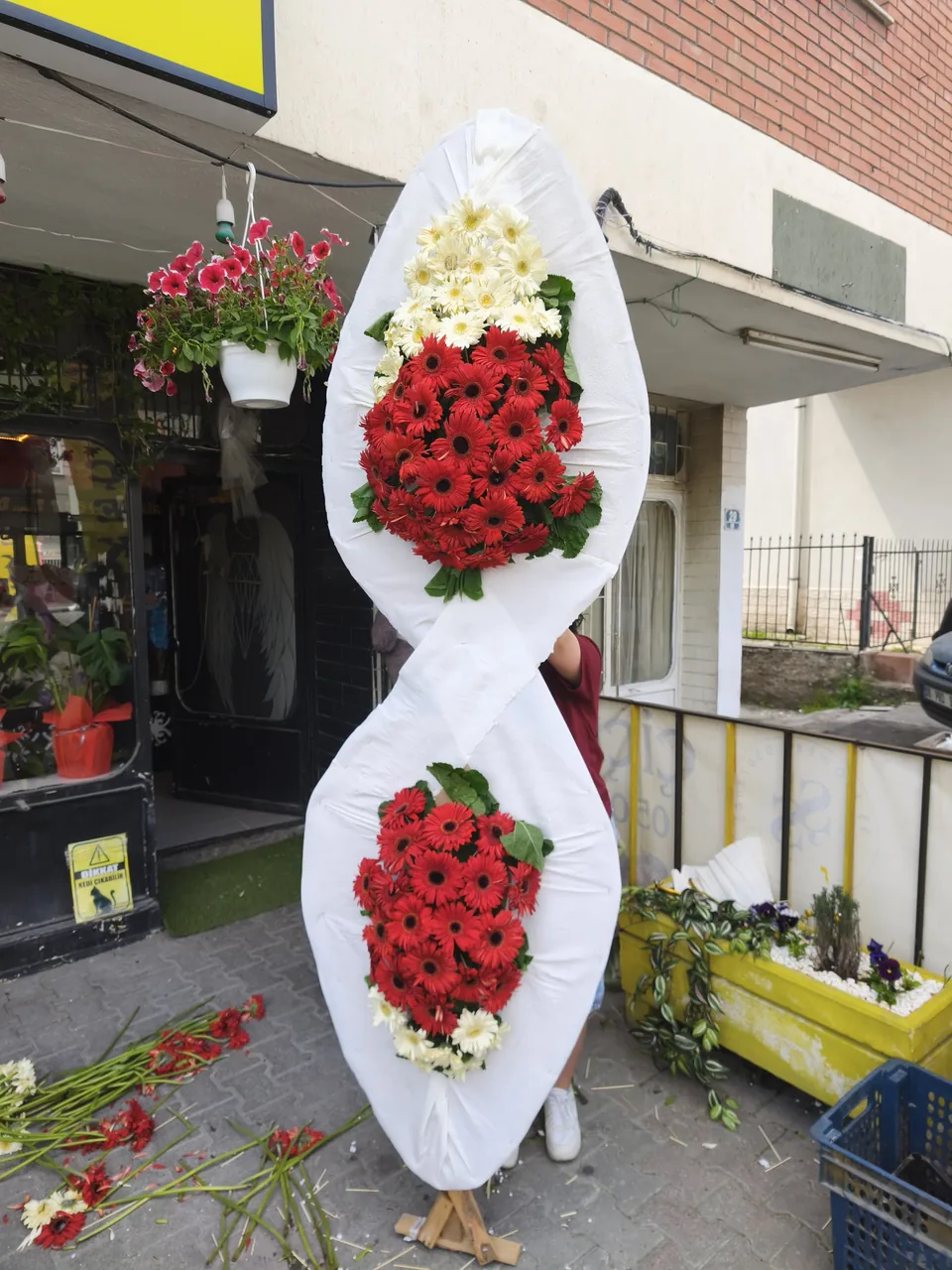 Kırmızı ve beyaz gerberalarla hazırlanmış çift katlı çelenk