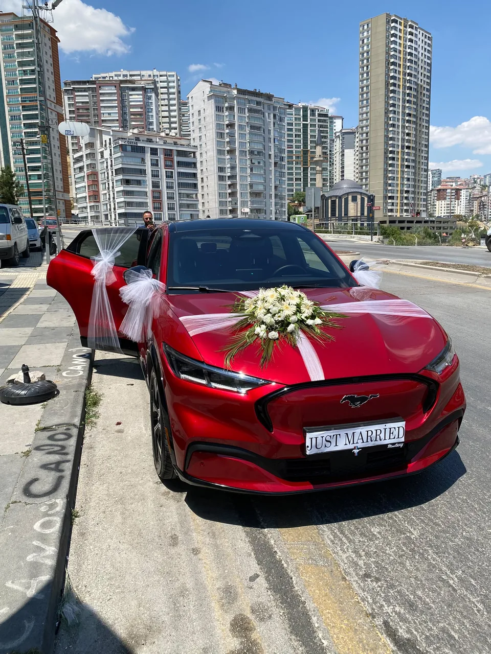 Kırmızı gelin arabası üzerinde beyaz çiçek ve tül süslemesi