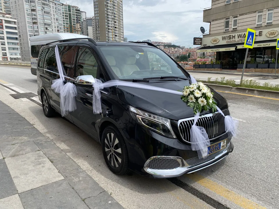 Siyah gelin arabası minibüsü üzerinde beyaz çiçek ve tül süslemesi